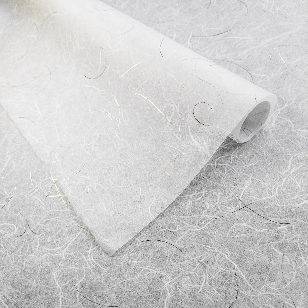 Handmade mulberry paper from Kozo Studio with delicate gold threads and a lightweight, ethereal texture on a white Unryu background
