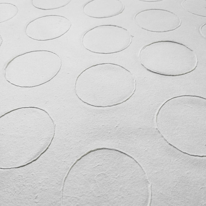 Beautiful circle-patterned mulberry paper made by Kozo Studio, highlighting its tactile handmade quality and suitability for collage or crafts.