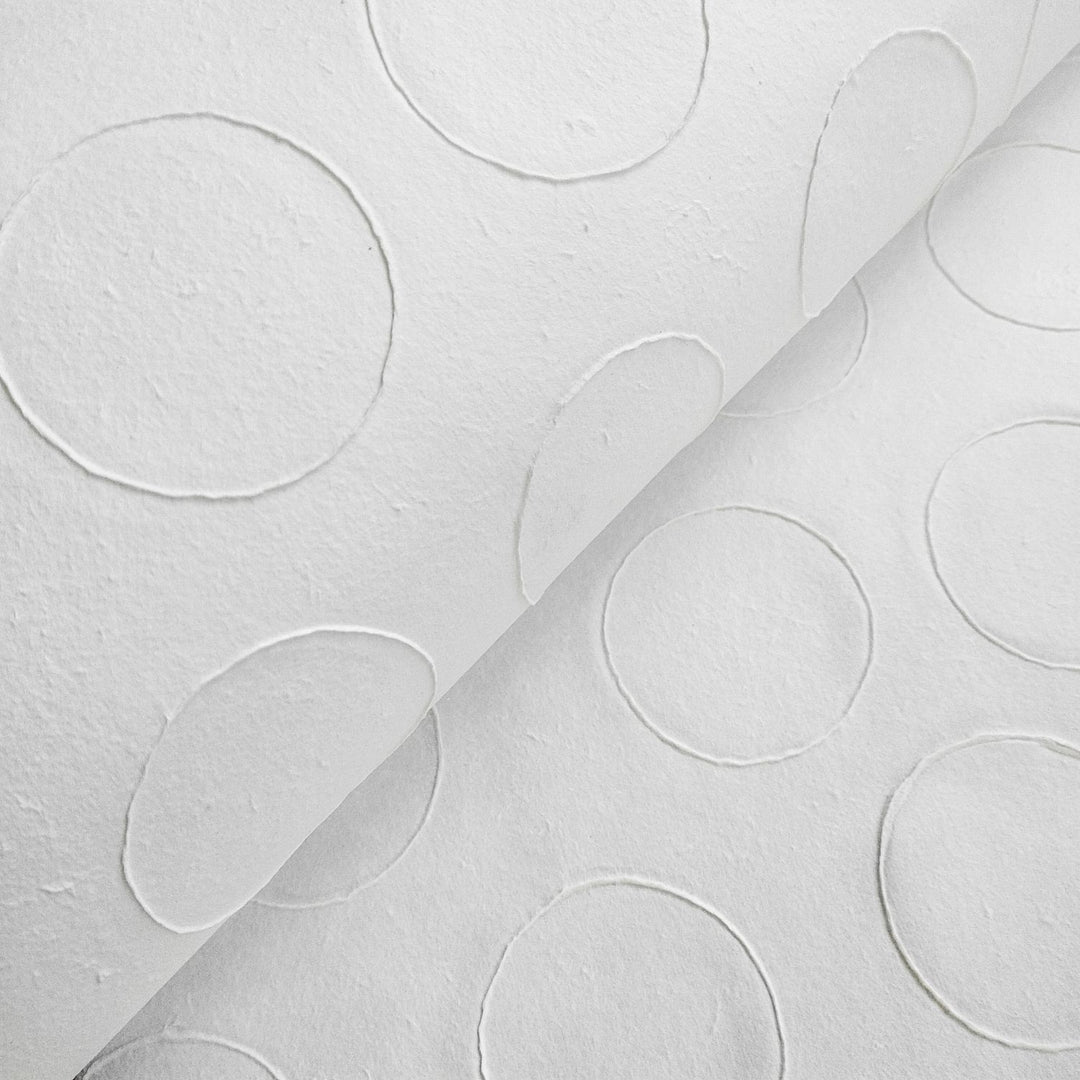 Artistic detail of Kozo Studio's handmade paper, showing the unique raised circle design on natural mulberry paper ideal for creative projects.