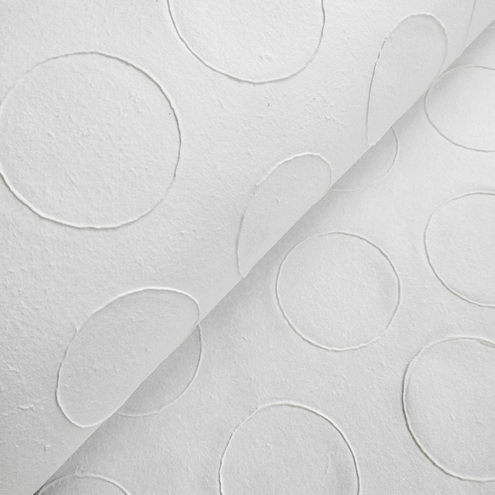 Artistic detail of Kozo Studio's handmade paper, showing the unique raised circle design on natural mulberry paper ideal for creative projects.