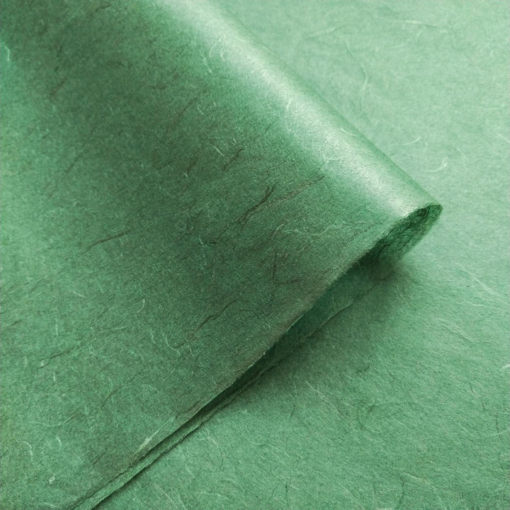 A macro view of handmade mulberry paper by Kozo Studio with layered folds and visible kozo fibers, capturing the essence of natural craftsmanship.