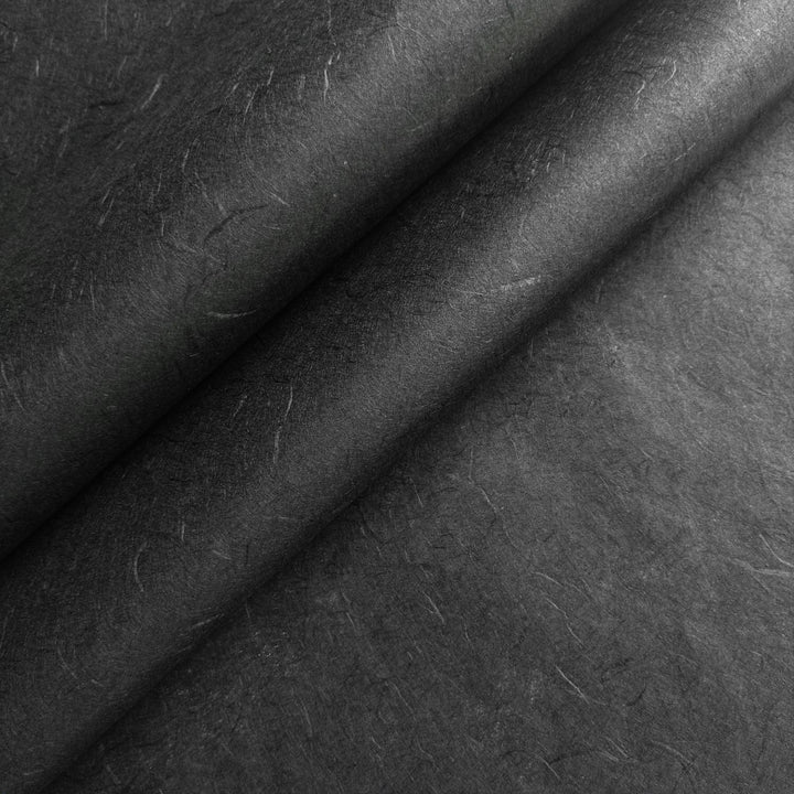 Close-up of black Unryu mulberry paper from Kozo Studio, showcasing the natural texture and layered folds of handmade paper.