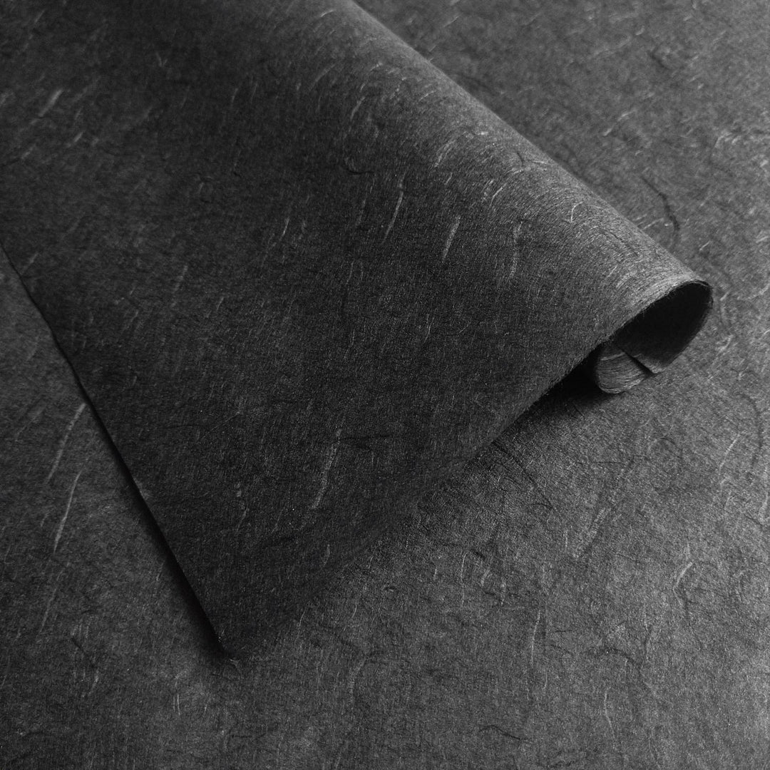 Detailed view of Kozo Studio handmade paper in black Unryu style, highlighting the textured surface and organic mulberry fibers.