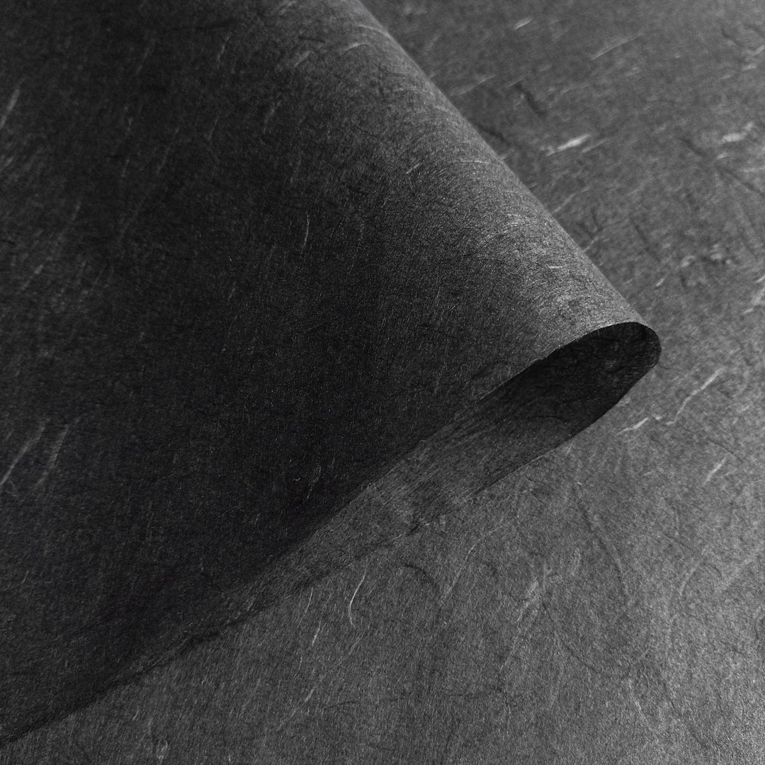 Kozo Studio Unryu paper in black mulberry, close-up showing sophisticated folds and the raw beauty of handmade paper.