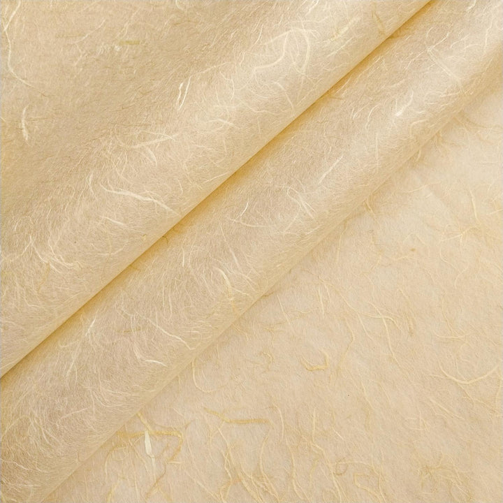 Close-up of pale beige Unryu mulberry paper from Kozo Studio featuring a folded, fibrous texture and visible handmade paper fibers.