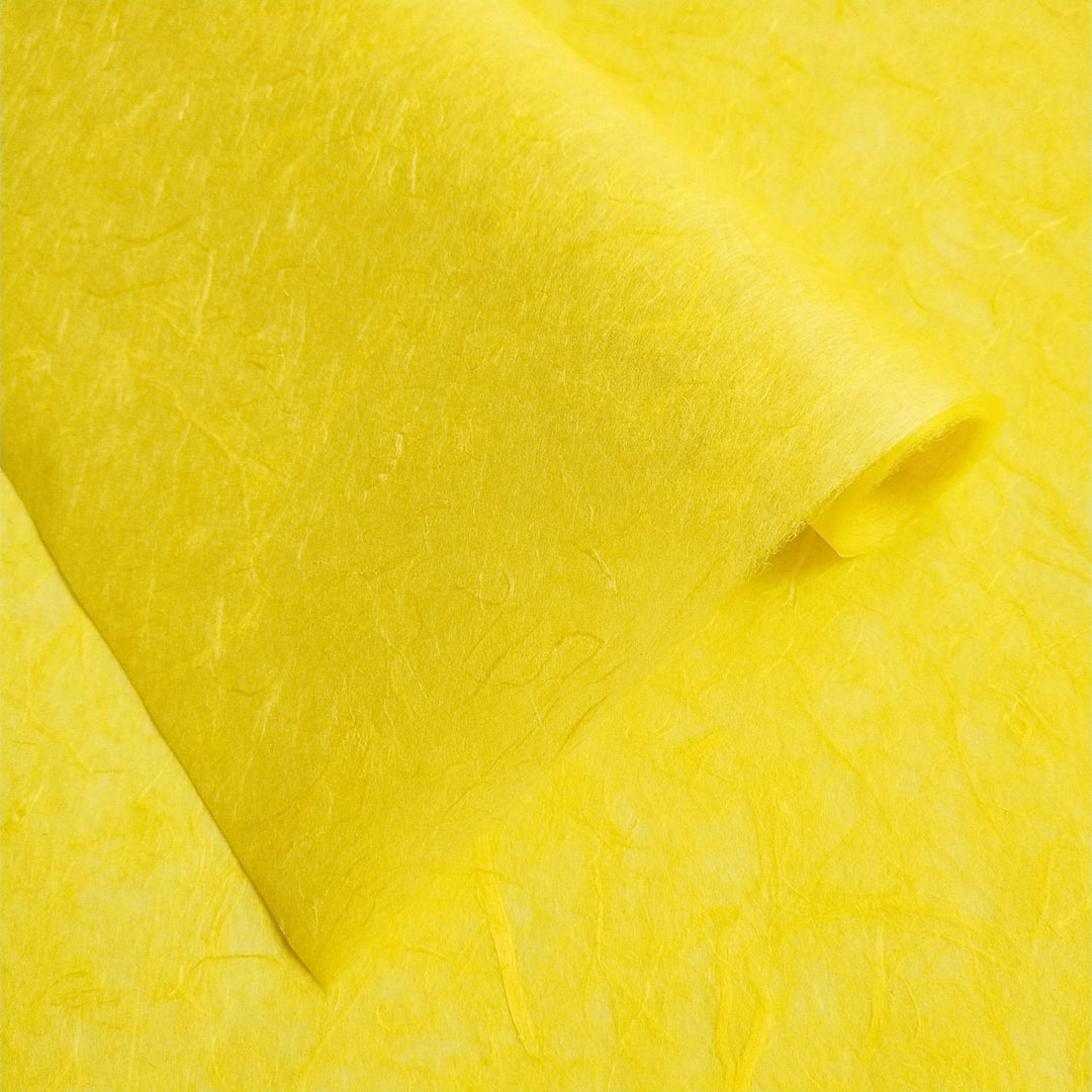 Vibrant yellow Unryu mulberry paper from Kozo Studio, featuring natural fibers and smooth handmade paper folds.