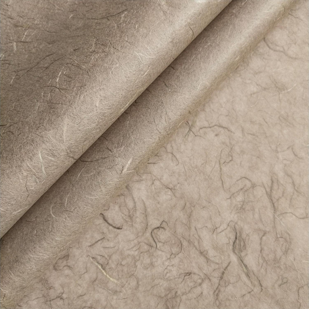 Close-up of Kozo Studio handmade paper showing fibrous layers and organic texture of grey mulberry paper.
