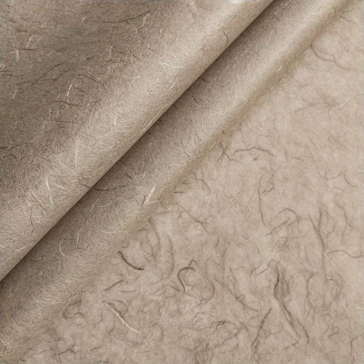 Close-up of Kozo Studio handmade paper showing fibrous layers and organic texture of grey mulberry paper.