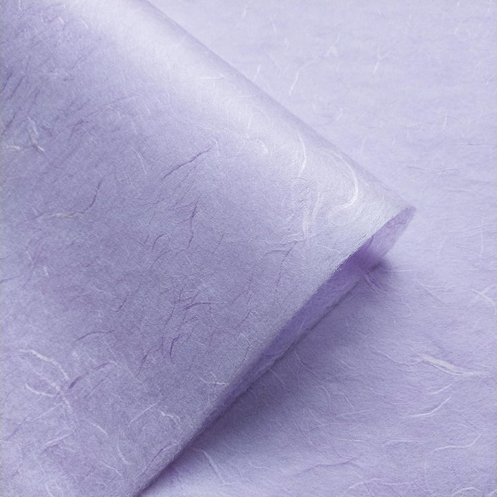 Heather purple mulberry paper from Kozo Studio displayed in overlapping layers, emphasizing the handcrafted quality and fibrous surface of this handmade paper.