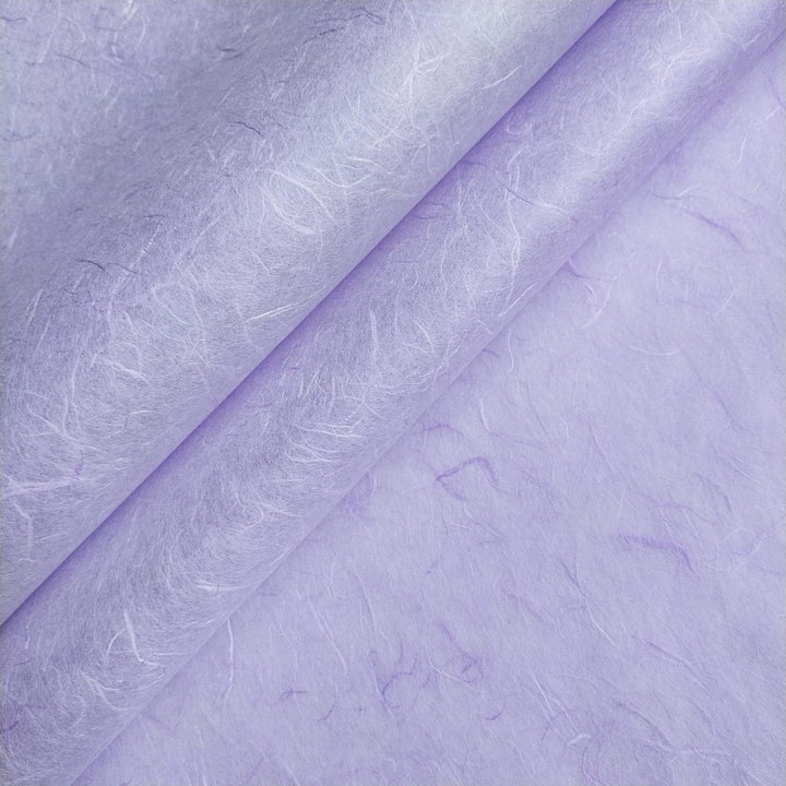 Close-up of overlapping sheets of Unryu mulberry paper in heather purple from Kozo Studio, highlighting the handmade paper texture and visible natural fibers.