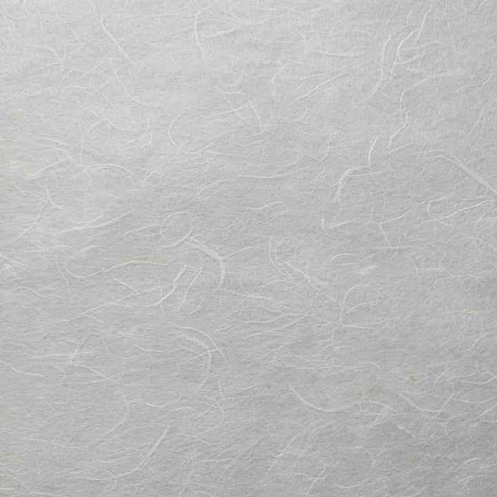 Close-up of Unryu Kozo Paper (White) by Kozo Studio, showcasing its textured surface with subtle fibrous patterns. Its soft, organic appearance features faint lines and swirls, reminiscent of traditional rice paper.