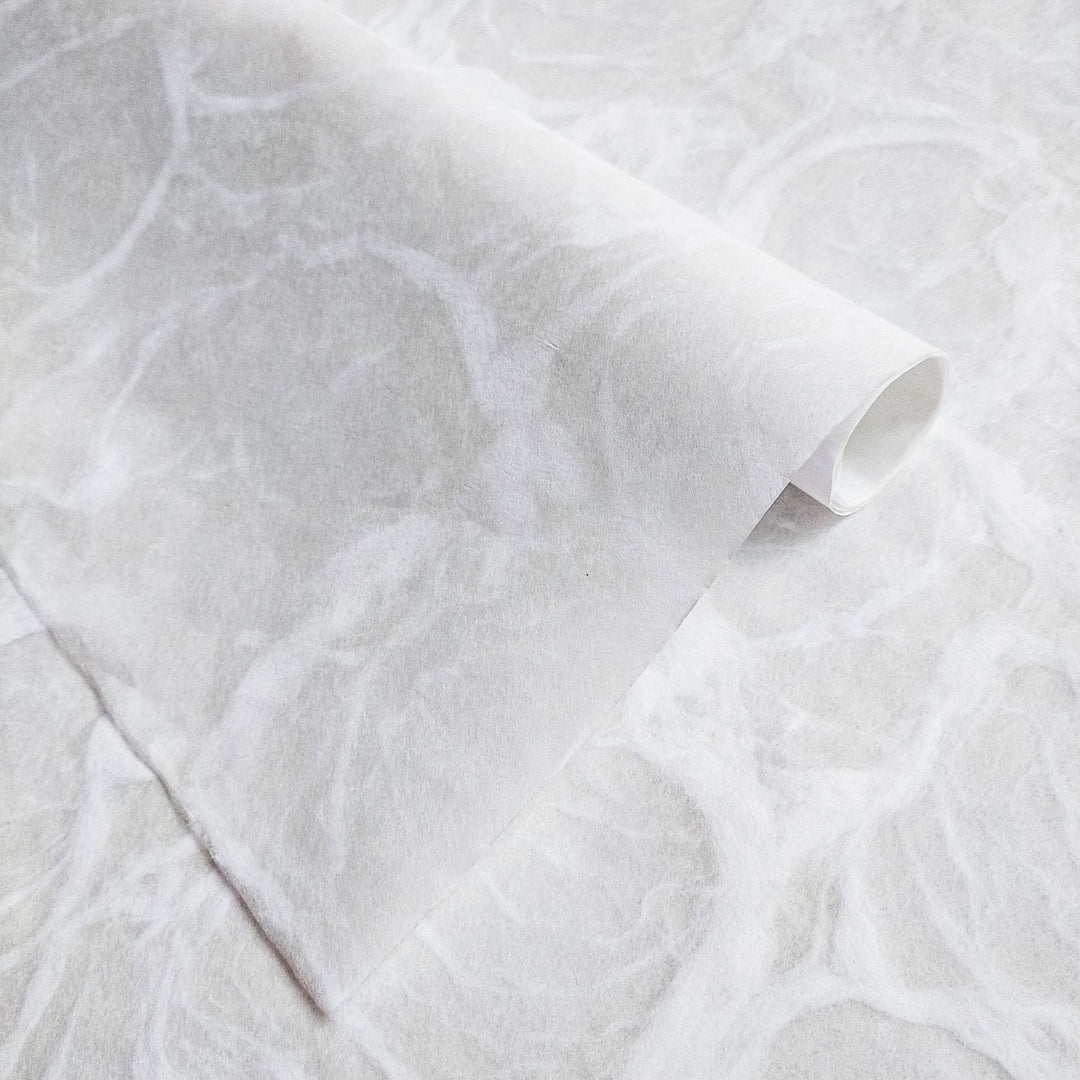 Ripple handmade paper in white by Kozo Studio, featuring a smooth fibrous surface with subtle wave-like patterns inspired by natural water ripples.