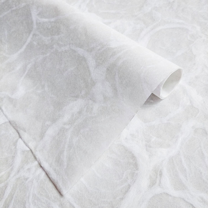 Ripple handmade paper in white by Kozo Studio, featuring a smooth fibrous surface with subtle wave-like patterns inspired by natural water ripples.