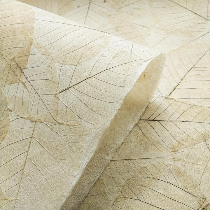 Close-up of Handmade Buddha Leaf Kozo Mulberry Paper (Natural) by Kozo Studio, showcasing its textured surface with embedded translucent leaf patterns. The beige hue, veins, and outlines give it a natural and organic look.