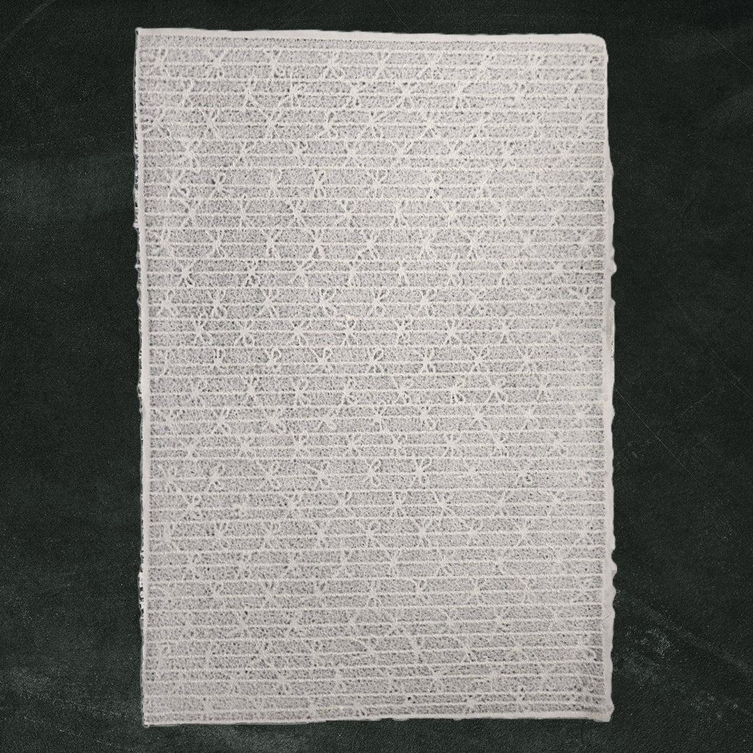 Translucent handmade Kozo Studio mulberry paper featuring intricate lace bow design, perfect for art and craft projects