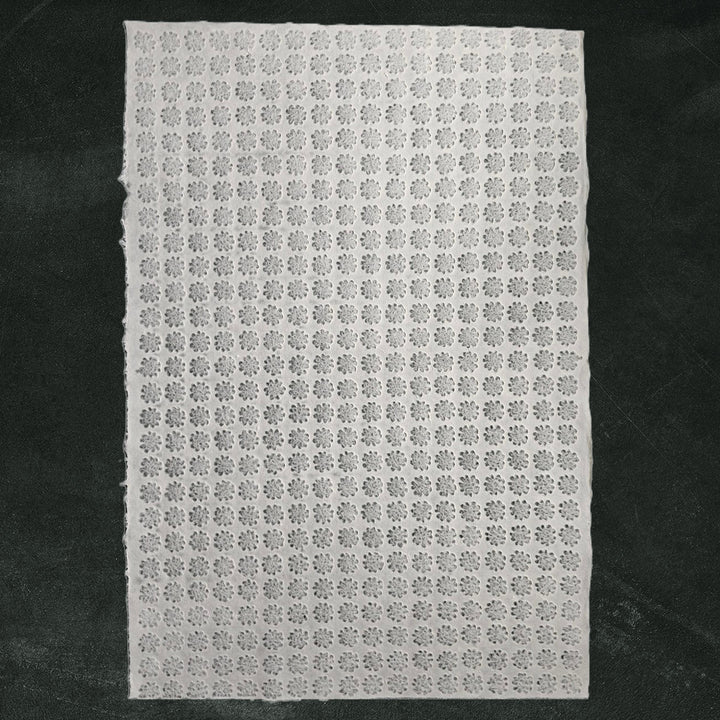 A close-up of white Handmade Kozo Paper with intricate floret designs, crafted using the Rakusui technique by Kozo Studio on premium mulberry paper.