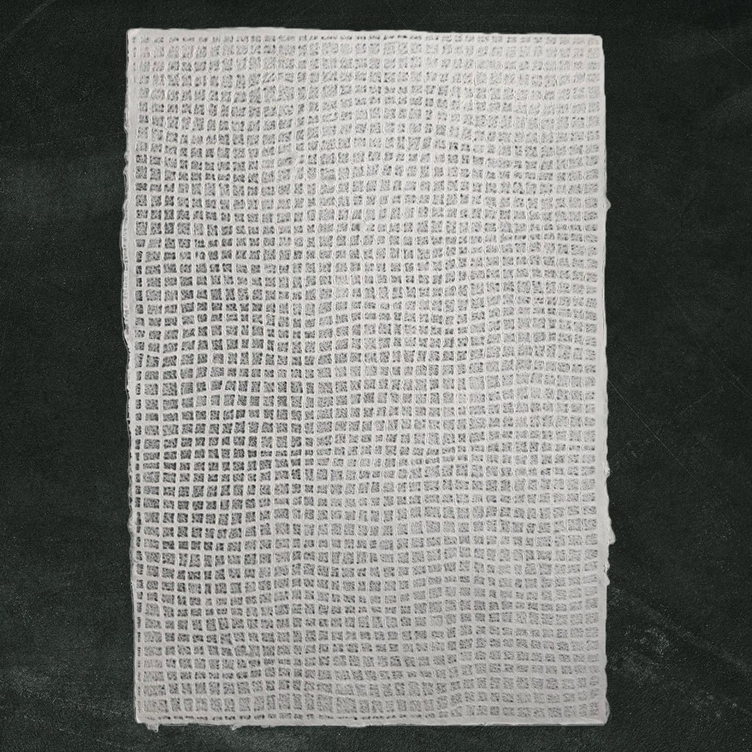 White lace-style mulberry paper crafted at Kozo Studio, featuring a translucent waffle pattern ideal for window coverings and other handmade paper crafts.