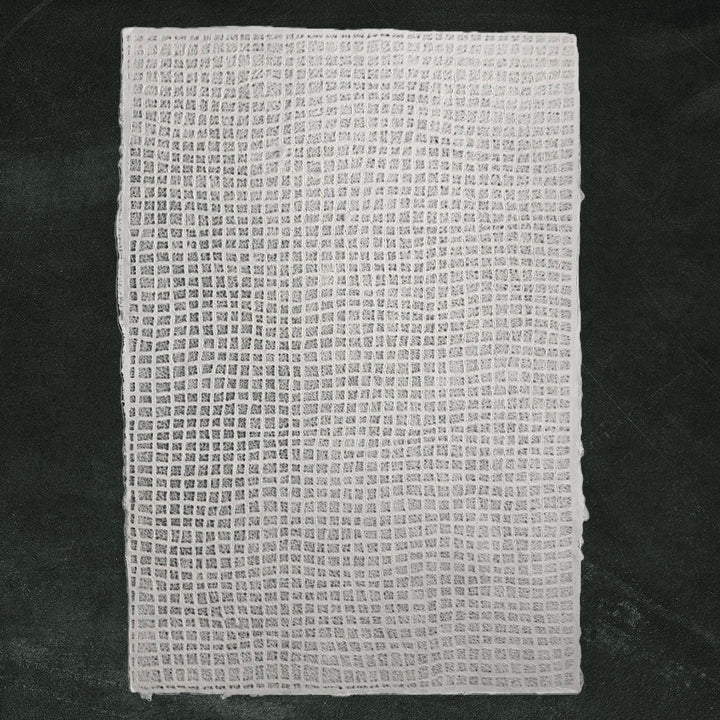 White lace-style mulberry paper crafted at Kozo Studio, featuring a translucent waffle pattern ideal for window coverings and other handmade paper crafts.