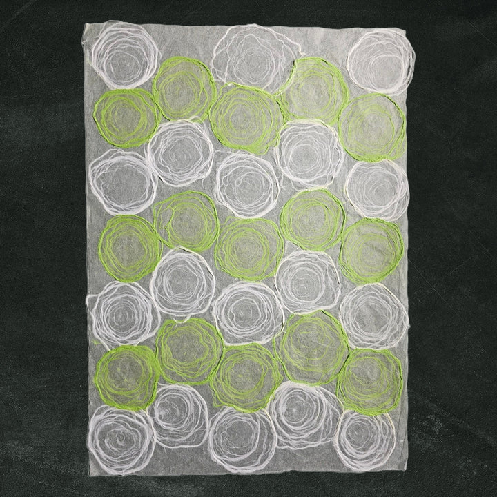 Artistic sheet of mulberry paper in green and white from Kozo Studio, crafted with hand-drawn circular pulp designs, ideal for elegant handmade paper projects.