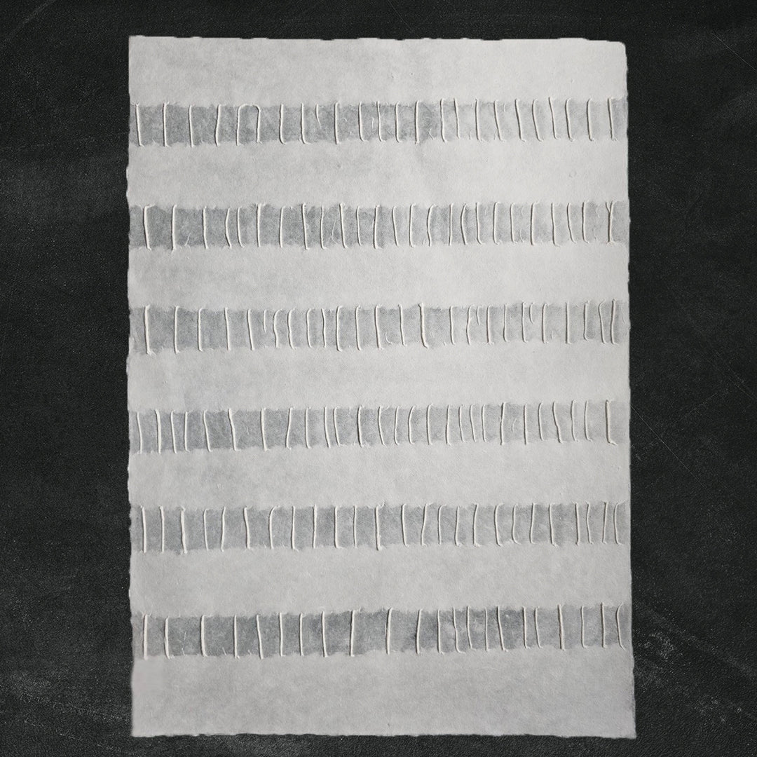 Detailed view of Kozo Studio's Fluo handmade paper showcasing the refined craftsmanship of white mulberry paper with a flowing linear design.