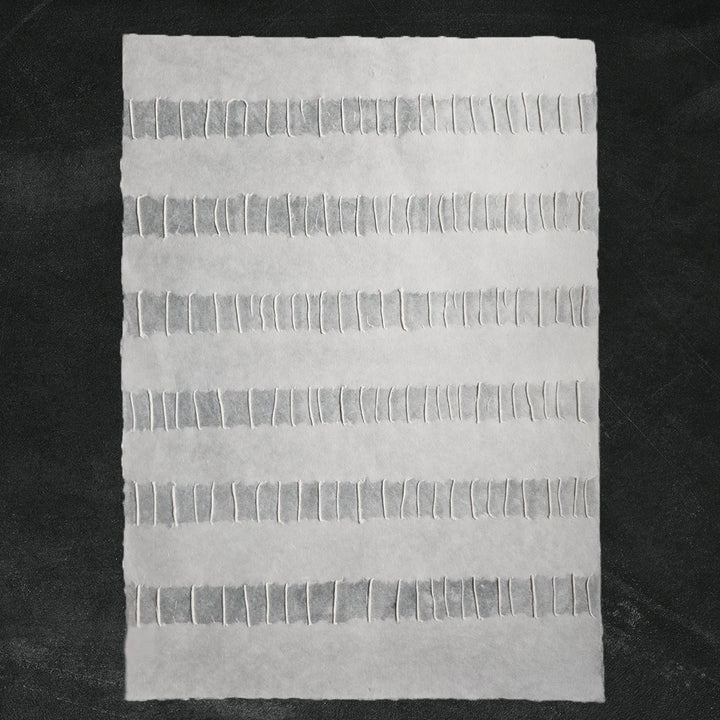 Detailed view of Kozo Studio's Fluo handmade paper showcasing the refined craftsmanship of white mulberry paper with a flowing linear design.