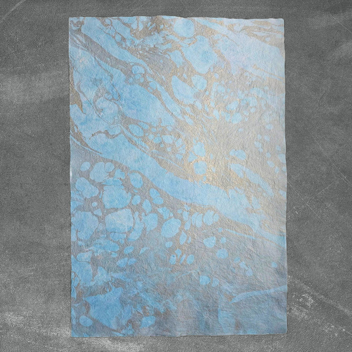 Elegant marbled handmade paper layered with mulberry fibers, designed by Kozo Studio with organic creases and vibrant oil-based patterns.