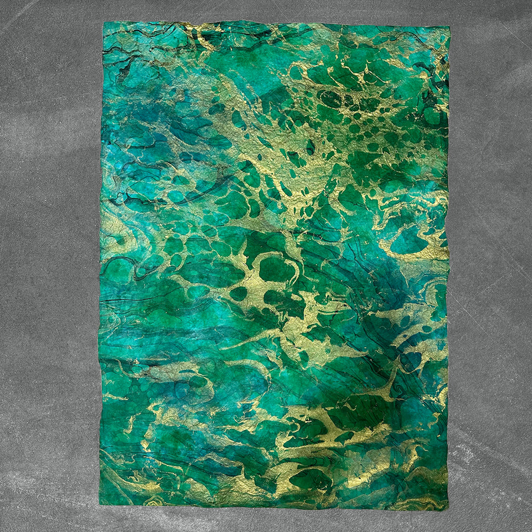 Unique sheet of Kozo Studio handmade paper featuring crinkled mulberry paper texture and swirling marbled design for elegant craft use.