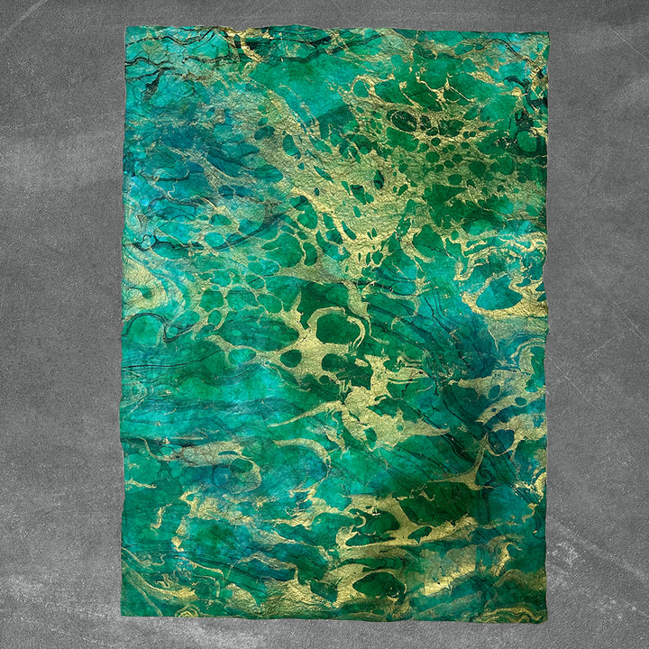Unique sheet of Kozo Studio handmade paper featuring crinkled mulberry paper texture and swirling marbled design for elegant craft use.