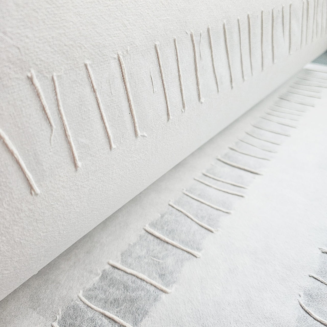 Artistic mulberry paper from Kozo Studio with a sophisticated blend of raised pulp lines and smooth white handmade paper stripes.