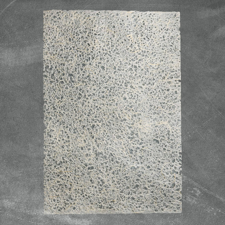 Handmade paper by Kozo Studio featuring Asarakusui technique with water-formed holes, showcasing fibrous layers of mulberry and abaca pulp.