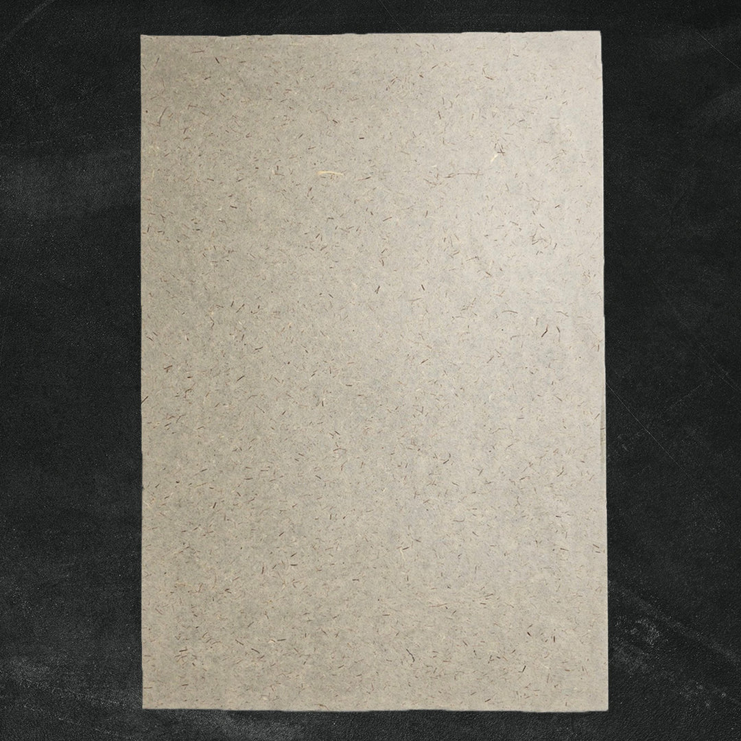 Kozo Studio mulberry paper with embedded pine leaves and visible fibers, offering an organic and textured surface ideal for handmade paper crafts and sustainable décor.