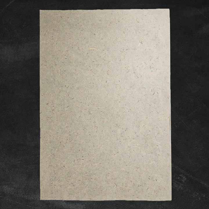 Kozo Studio mulberry paper with embedded pine leaves and visible fibers, offering an organic and textured surface ideal for handmade paper crafts and sustainable décor.