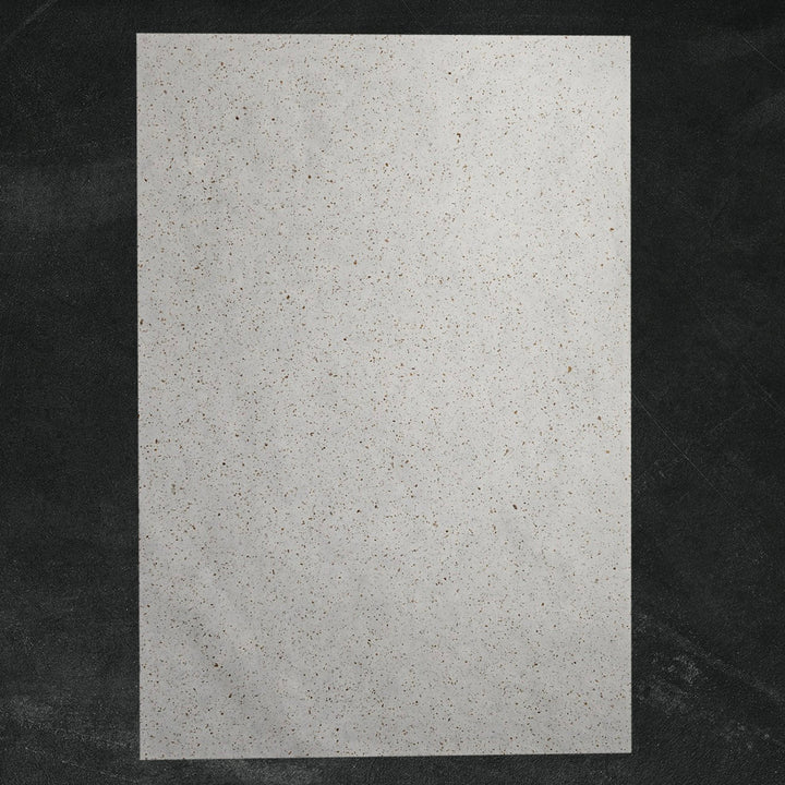 Decorative Tobac Confetti Kozo handmade paper by Kozo Studio, made from mulberry fibers and embedded with natural leaf confetti for a unique speckled appearance.