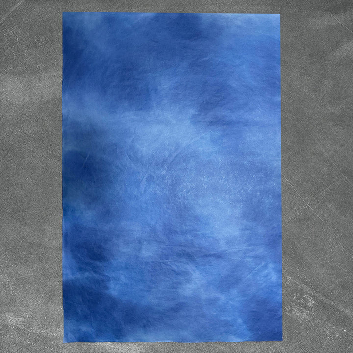 A close-up of handmade paper by Kozo Studio showcasing a stunning gradient effect in blue tones, crafted from high quality mulberry paper for unique DIY applications.