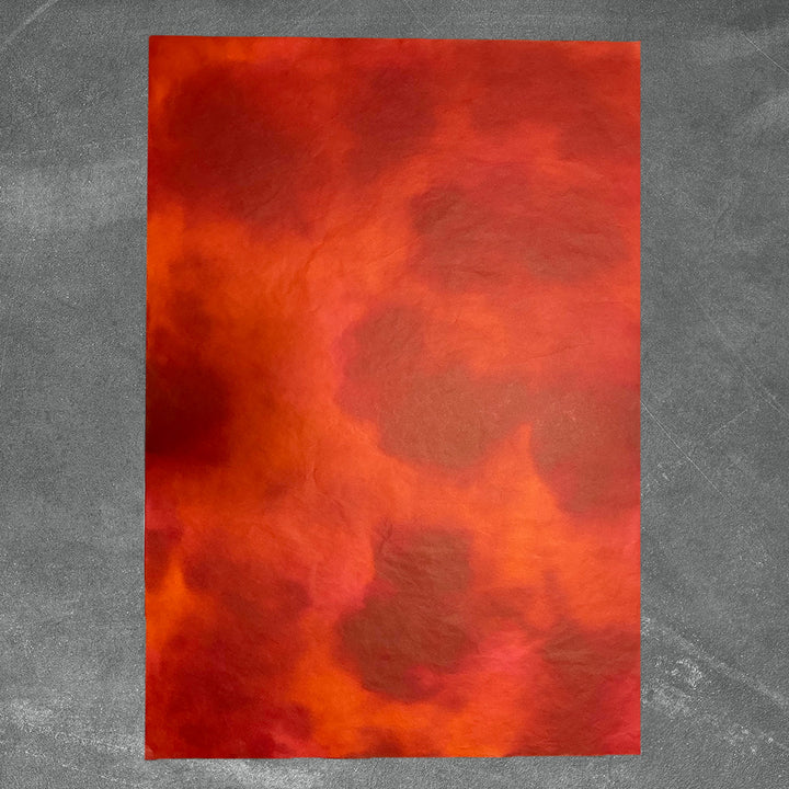 Close-up of Kozo Studio's ombre mulberry paper, showcasing its handmade quality and subtle red color variations from light to dark.