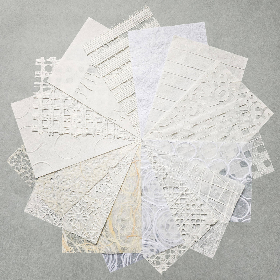The A4 Texture Treasure Kozo Paper Pack #1 by Kozo Studio features white and off-white textured papers, including Mulberry, arranged in a circular overlap on gray. It showcases patterns like grids, circles, and florals.
