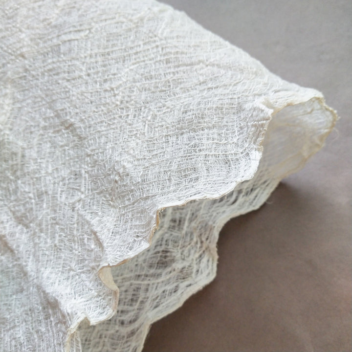 Art-grade mulberry bark material from Kozo Studio with visible natural holes and folds, ideal for artists seeking flexible and authentic paper textures.