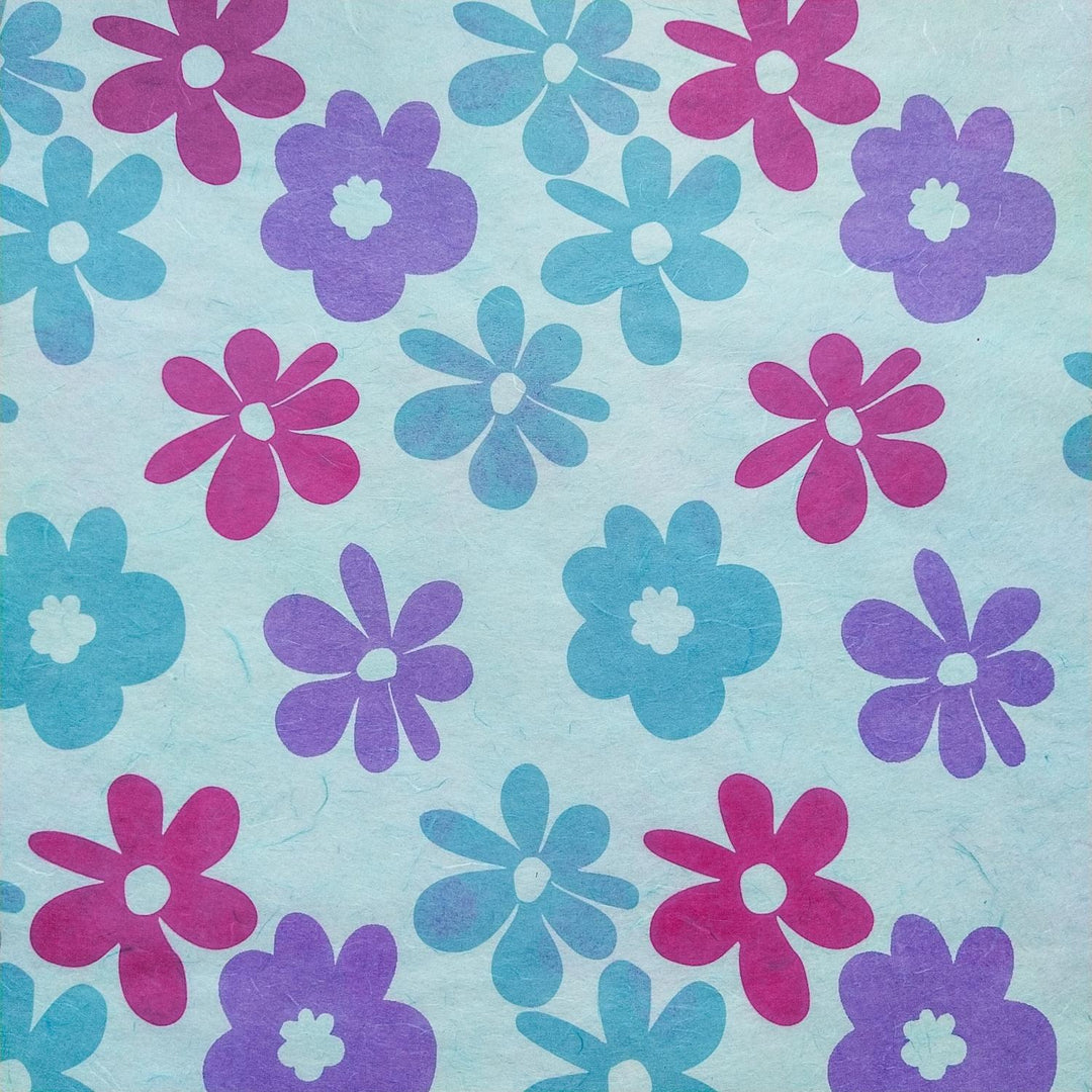 Handmade Caribbean floral mulberry paper from Kozo Studio, screen-printed with pink, purple, and blue flowers on a sky blue background.