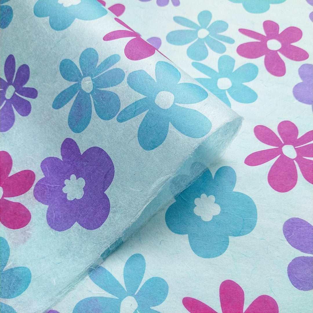 Sky blue handmade paper from Kozo Studio, featuring a layered look with translucent mulberry texture and colorful tropical floral screen printing.