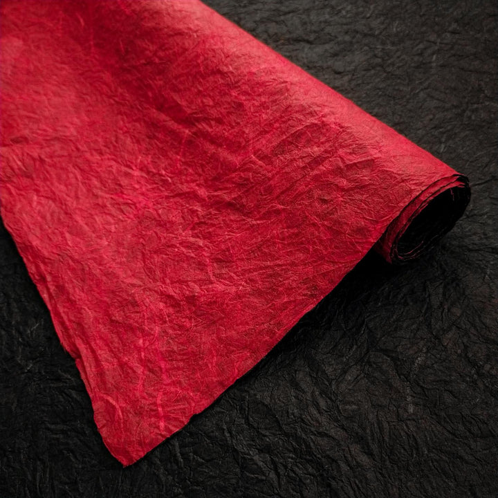 Detailed view of double-sided Momigami mulberry paper from Kozo Studio, showcasing its rough handmade texture and bold red and black contrast.