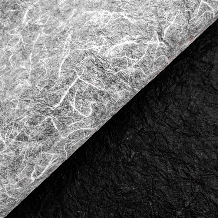 Fibrous surface of Kozo Studio’s handmade paper with black and white sides, crafted from textured mulberry paper ideal for unique art and design work.