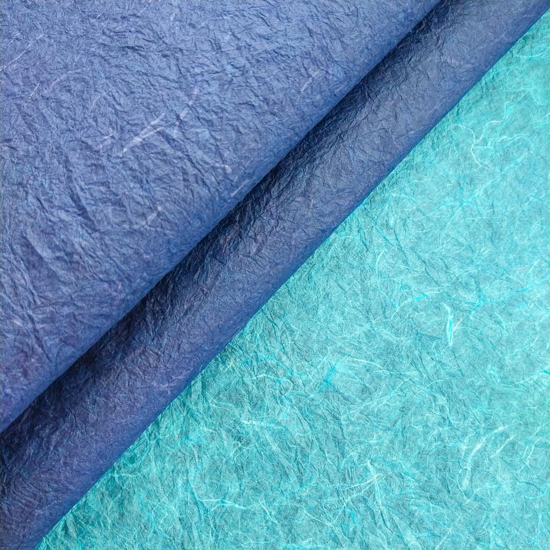 Close-up texture of Kozo Studio's handmade paper, featuring curled mulberry paper with dual tones and fine fibrous detailing for craft inspiration.