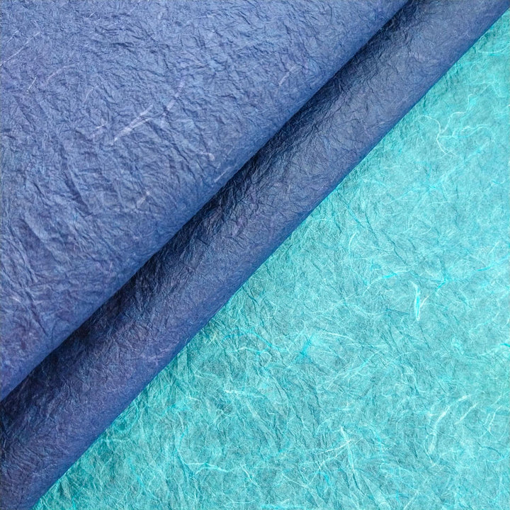 Close-up texture of Kozo Studio's handmade paper, featuring curled mulberry paper with dual tones and fine fibrous detailing for craft inspiration.