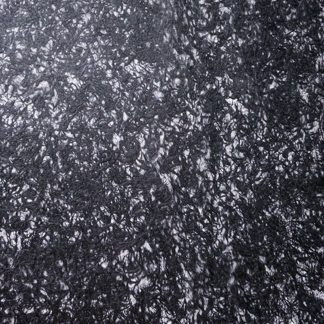 Beautifully handcrafted mulberry paper by Kozo Studio, displaying a light, airy structure with embedded fibers, ideal for collage, décor, and custom design work.