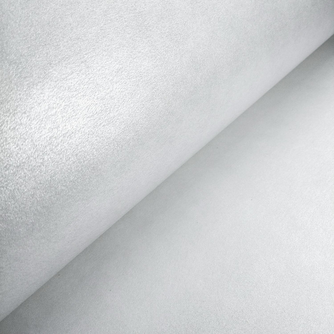 Reflective metallic mulberry paper by Kozo Studio, made from kozo fiber, rolled out to display its fine handmade texture and silver-toned shine.