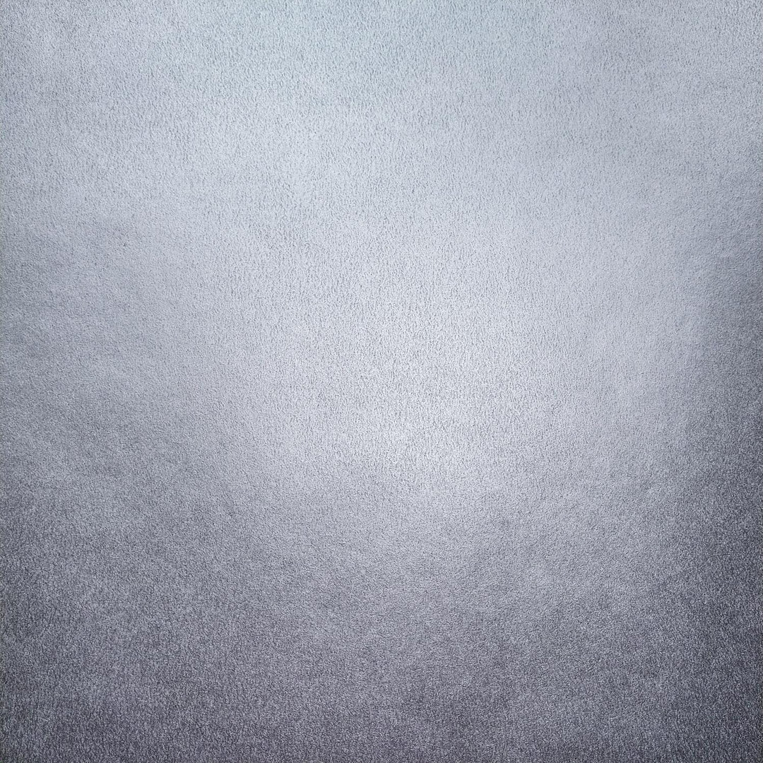 A sheet of Gleaming Metallic Kozo handmade paper from Kozo Studio, showing shiny silver finish with natural mulberry paper texture and elegant curl.