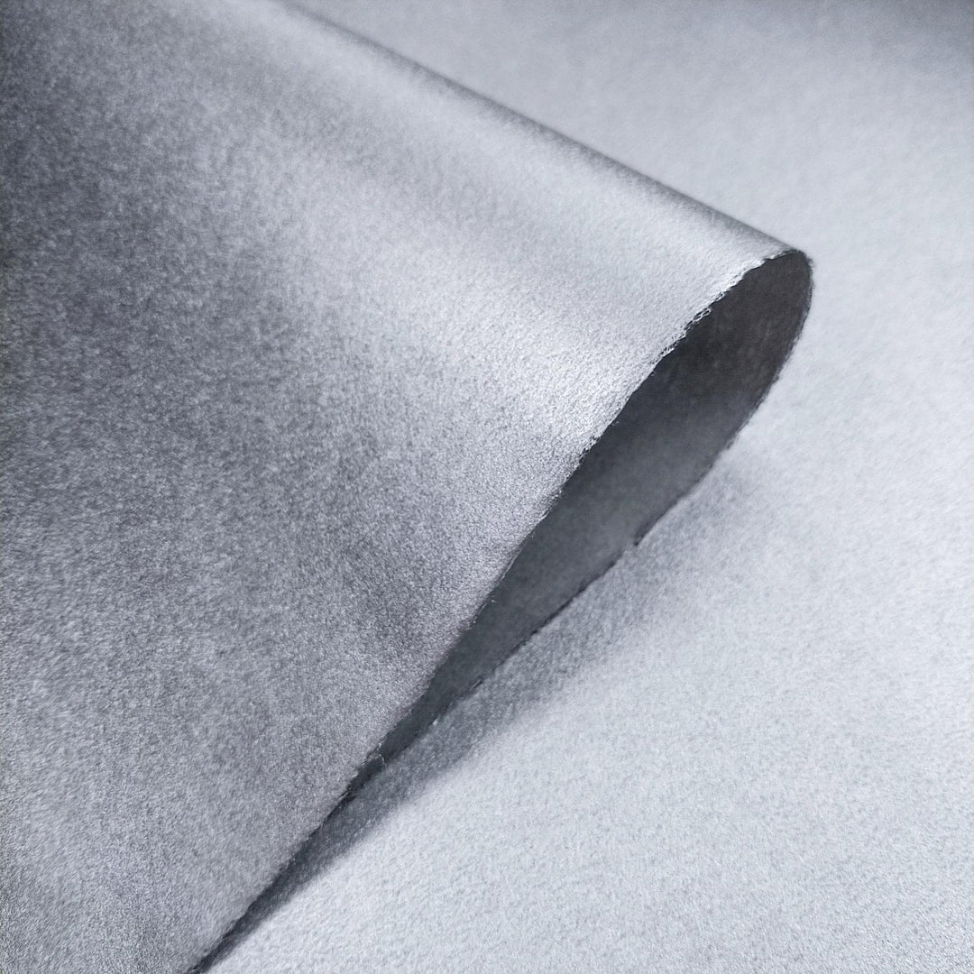 High-resolution image of handmade mulberry paper from Kozo Studio, featuring a shimmering metallic surface and delicate kozo fiber details.