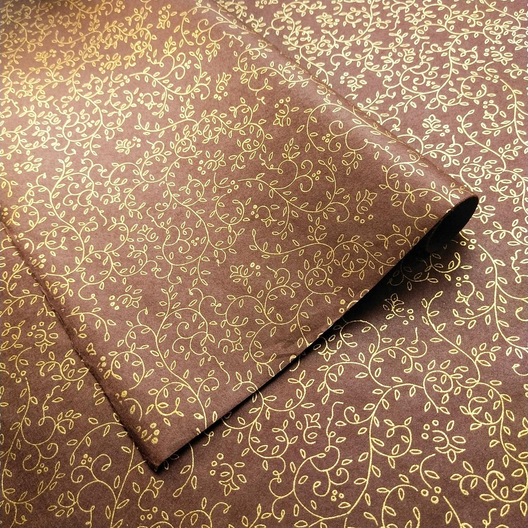 Close-up of Kozo Studio mulberry paper featuring a brown base with gold screen-printed floral vines and leaves, highlighting the luxury of handmade paper.