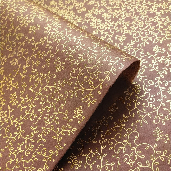 Detail view of Kozo Studio's grapevine design on brown mulberry paper with gold screen print, exemplifying fine handmade paper artistry.