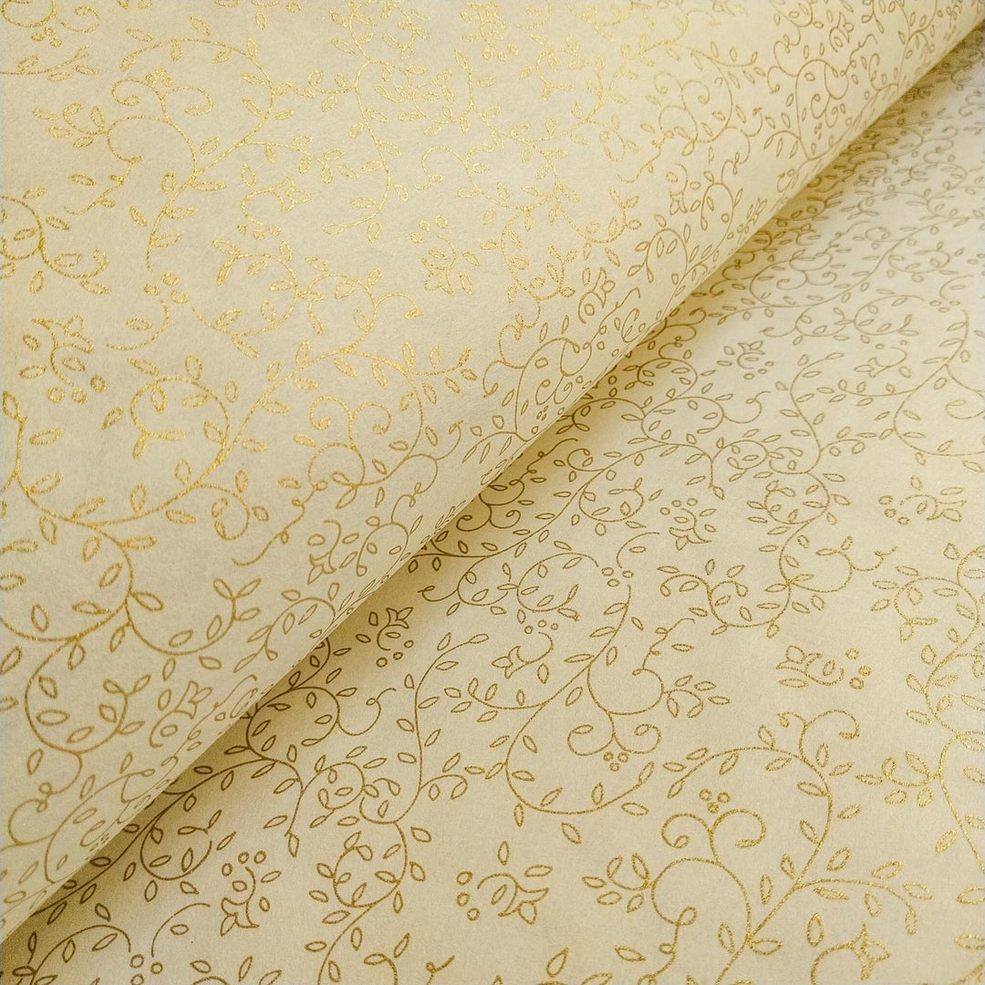 A close-up of Kozo Studio mulberry paper showing a refined gold vine and leaf pattern on luxurious ivory handmade paper.